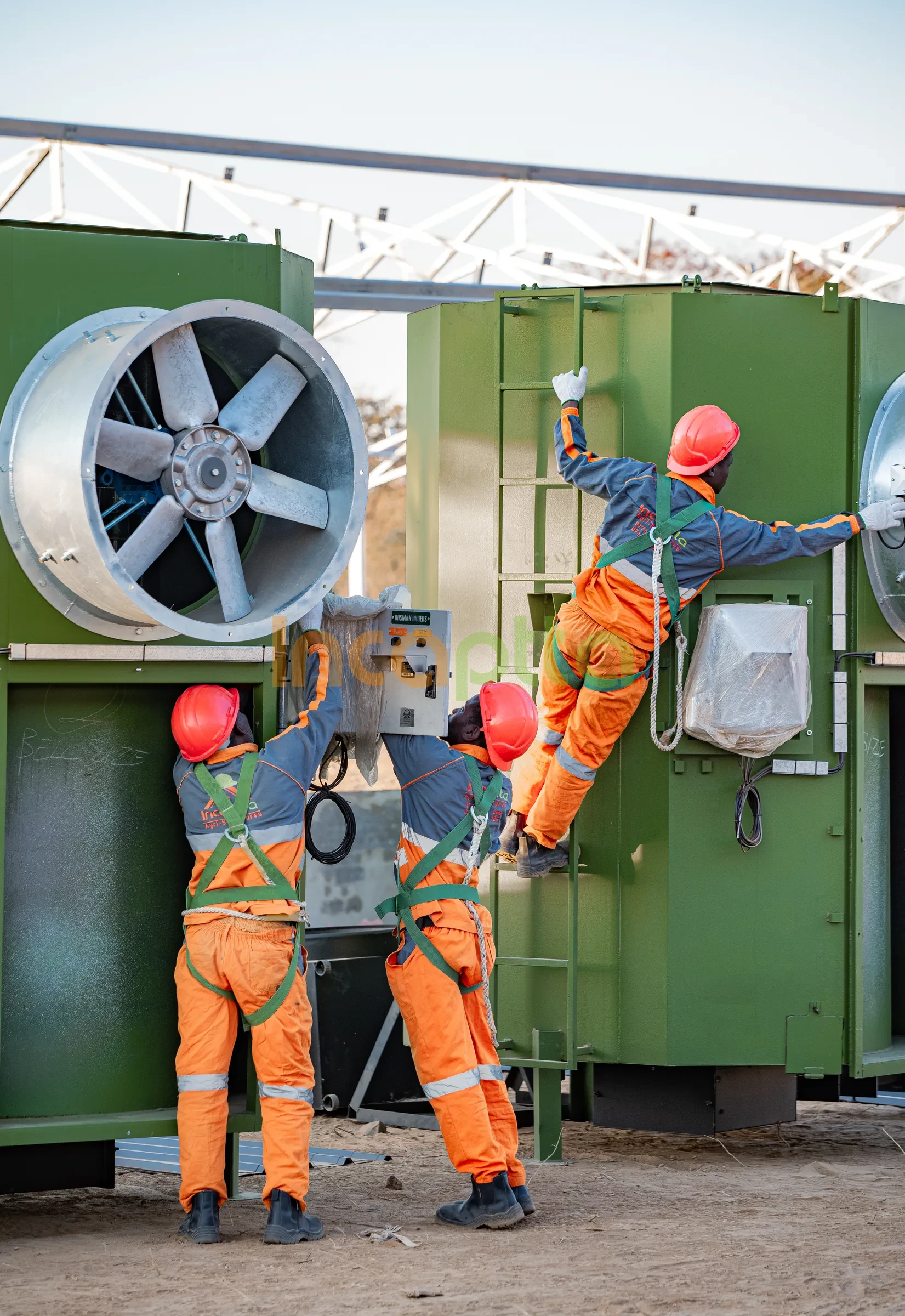 Incaptta technicians installing olive-green climate units with industrial fans on site
